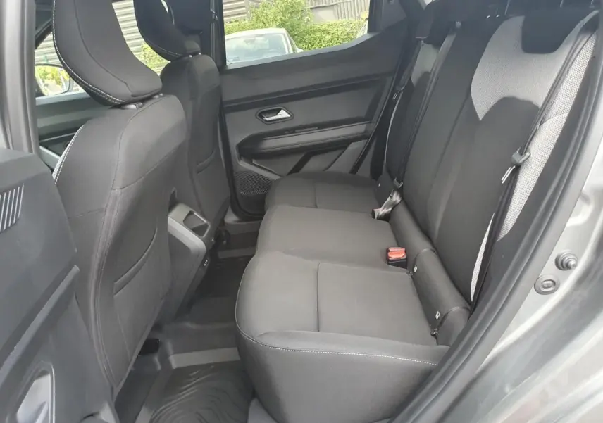 Vue intérieure arrière côté droit du Dacia Duster gris schiste, montrant la banquette arrière et les prises USB à la console centrale.