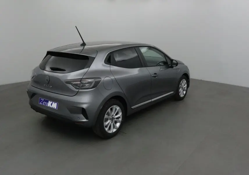 Renault Clio V gris schiste vue 3/4 arrière droit, avec protections latérales chromées et jantes alliage 16 pouces.