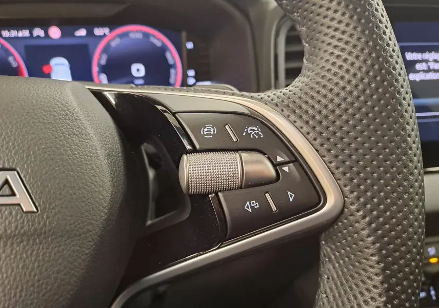 Gros plan sur les commandes à droite du volant perforé du Skoda Karoq Bleu RS 2025 avec affichage numérique en arrière-plan