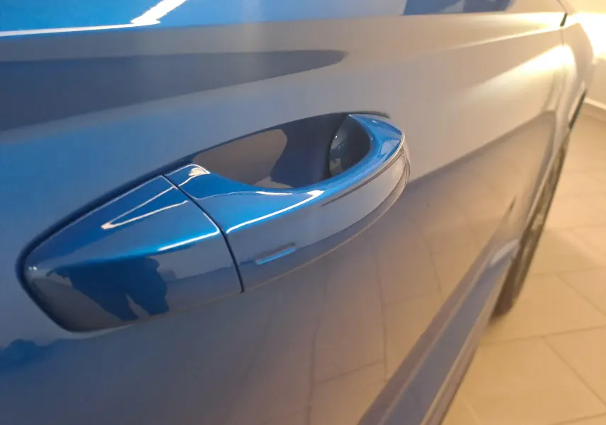 Poignée de porte côté gauche en gros plan sur Skoda Karoq Bleu RS 2025 avec peinture métallisée brillante.
