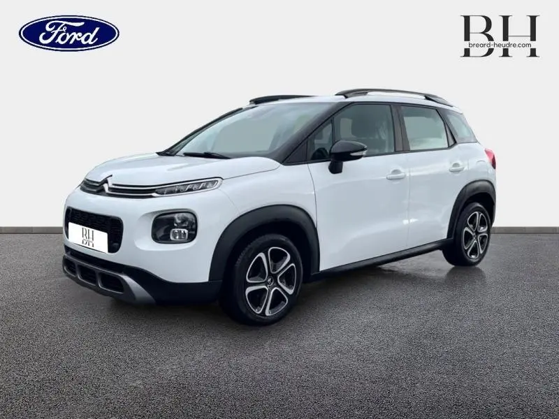 Citroën C3 Aircross blanc Natural White vue 3/4 avant droit avec barres de toit et jantes distinctives.