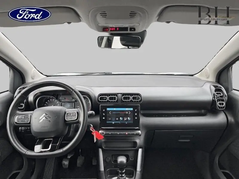 Vue intérieure avant du Citroën C3 Aircross 2019, tableau de bord noir avec écran tactile et volant cuir multifonctions.