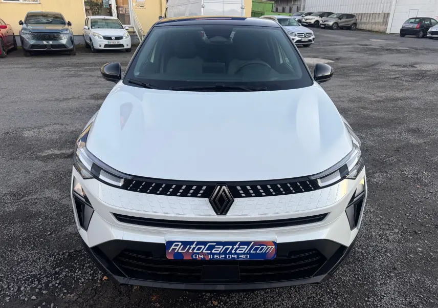 Vue avant d'un Renault Captur E-Tech Full Hybrid blanc nacré avec toit noir, mettant en valeur sa calandre moderne et ses phares LED.