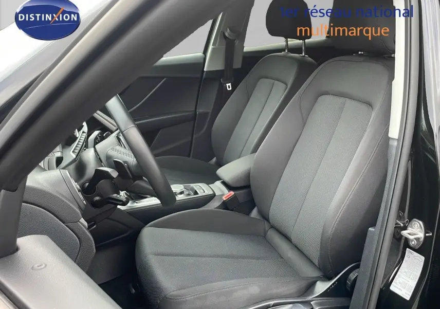 Vue intérieure côté conducteur de l'Audi Q2 35 TFSI 2023 avec sièges tissu gris et tableau de bord noir.