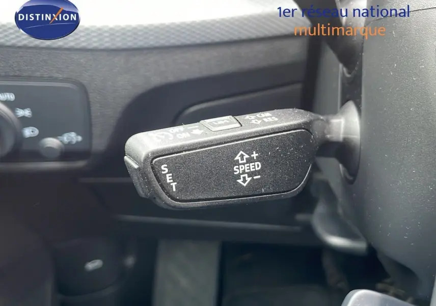 Gros plan sur le levier de régulateur de vitesse à gauche du volant dans l'Audi Q2 noir mito metal 2023.