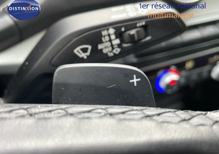 Gros plan sur la palette de changement de vitesse droite et commandes de climatisation dans l’habitacle d’un Audi Q2 noir.