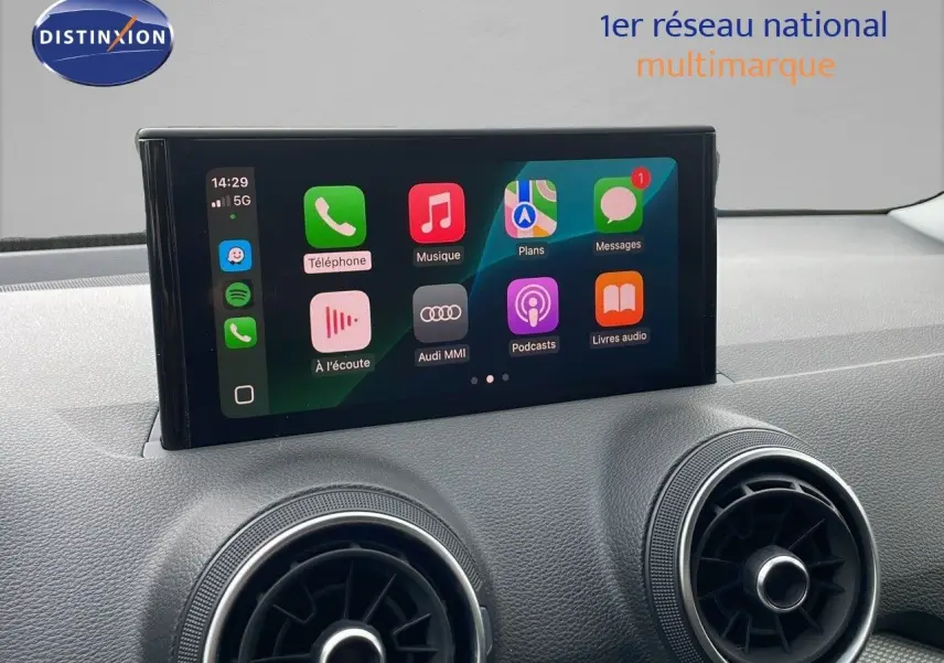 Écran tactile central affichant Apple CarPlay dans l’habitacle d’un Audi Q2 noir mito metal, vue de face rapprochée.