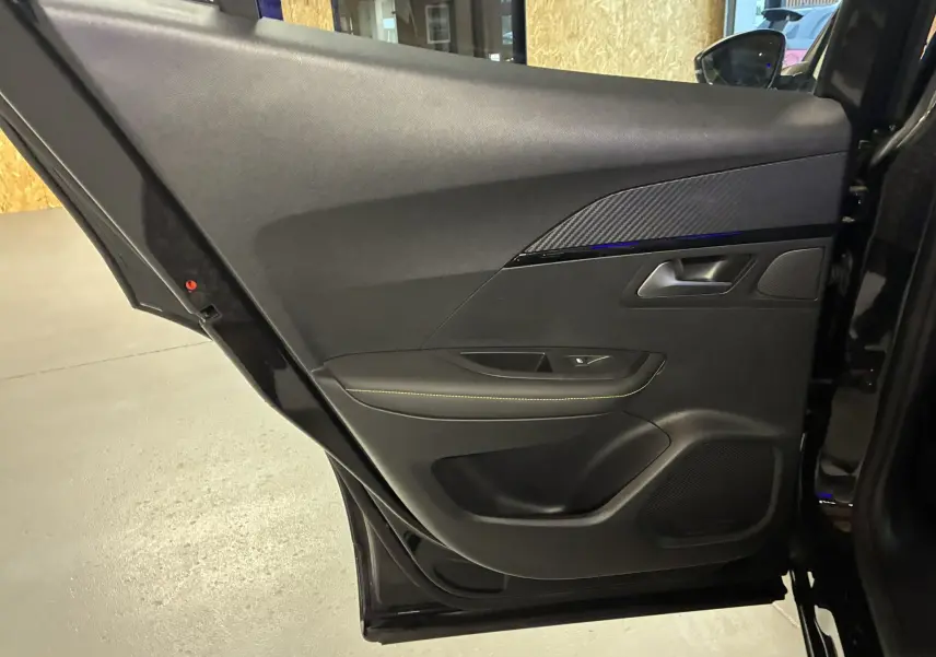 Porte arrière droite ouverte du Peugeot 2008 noir, montrant le panneau intérieur avec garniture noire et surpiqûres jaunes.