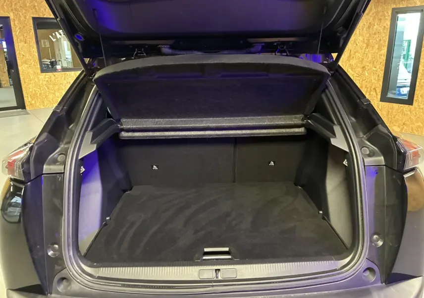 Coffre ouvert vu de l'arrière d'un Peugeot 2008 noir 2020, montrant l'espace de chargement et la tablette cache-bagages.