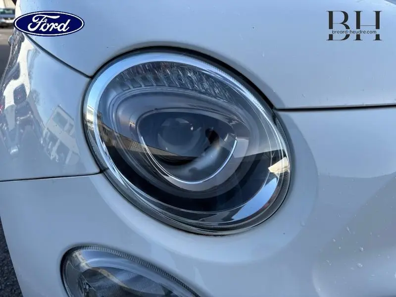 Gros plan sur le phare avant droit blanc Bossa Nova d'une FIAT 500 Dolcevita 2022 avec détails chromés.