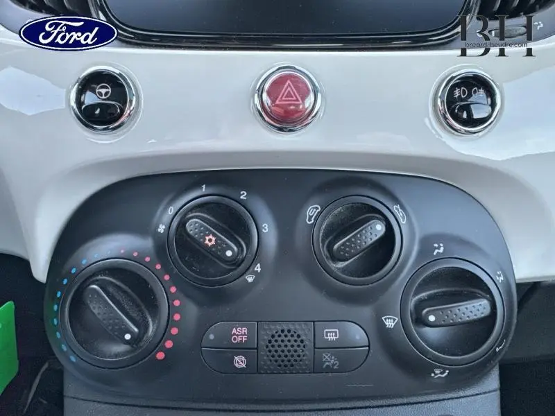 Vue rapprochée du tableau de bord blanc Bossa Nova White Pastel de la Fiat 500 avec commandes de climatisation et boutons rouges et noirs.