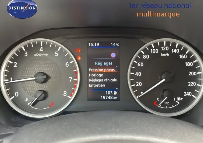 Tableau de bord de Nissan Juke 2023 avec compte-tours, vitesse, écran central affichant réglages et kilométrage.