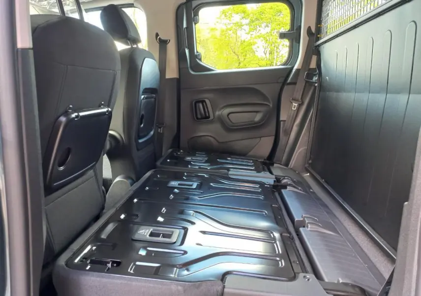 Vue intérieure côté droit de l’Opel Combo LIFE Elegance M 2025 bleu, sièges arrière rabattus et plancher de chargement visible.