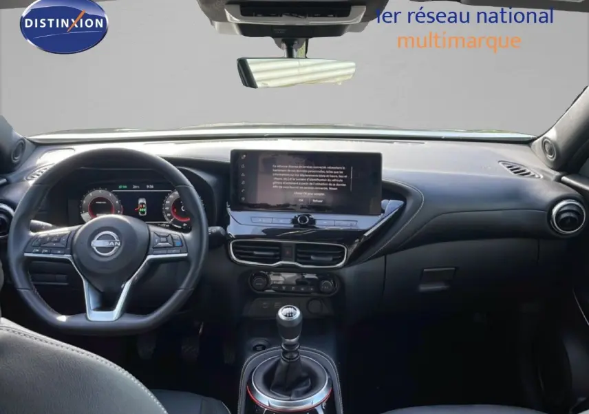 Vue intérieure avant du Nissan Juke 2025 noir Kuro Metal, tableau de bord moderne avec écran central et boîte manuelle.