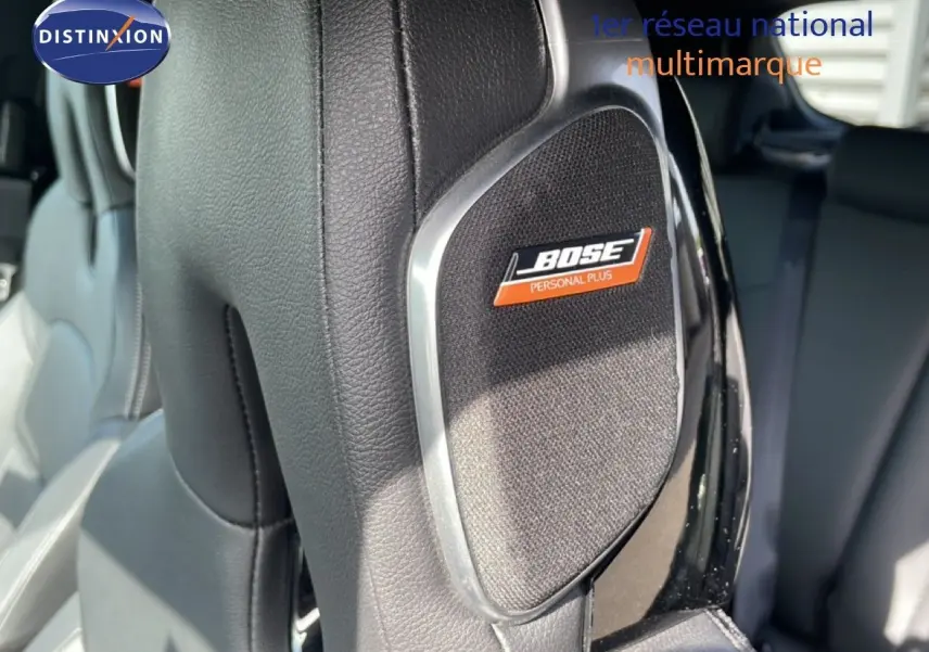 Détail du haut-parleur Bose intégré dans l'appui-tête en cuir noir du Nissan Juke 2025, version Tekna.