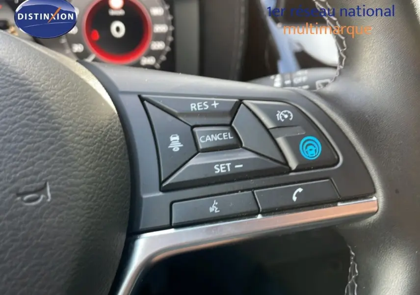 Gros plan sur les commandes au volant du Nissan Juke noir Kuro Metal, avec boutons de régulateur et appel téléphonique.