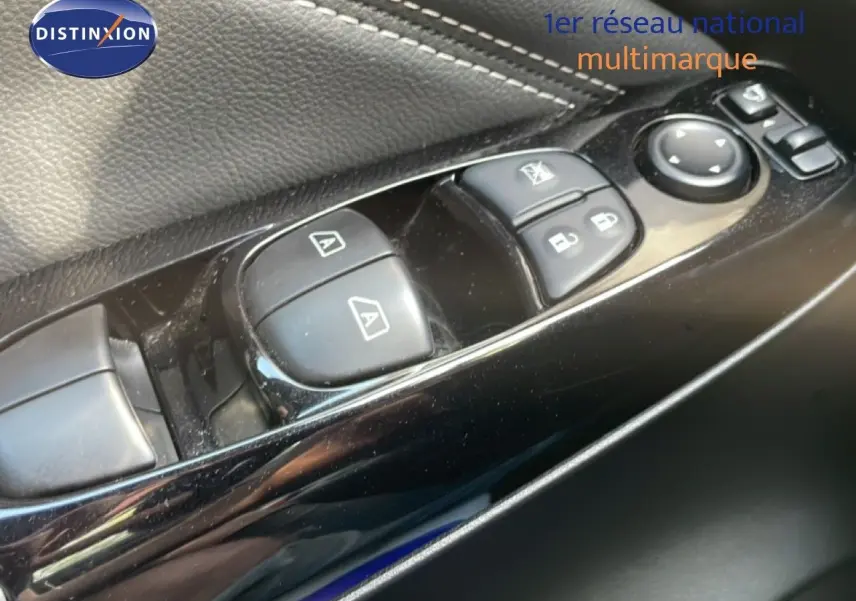 Gros plan sur les commandes de lève-vitres et rétroviseurs côté conducteur du Nissan Juke noir Kuro Metal 2025.