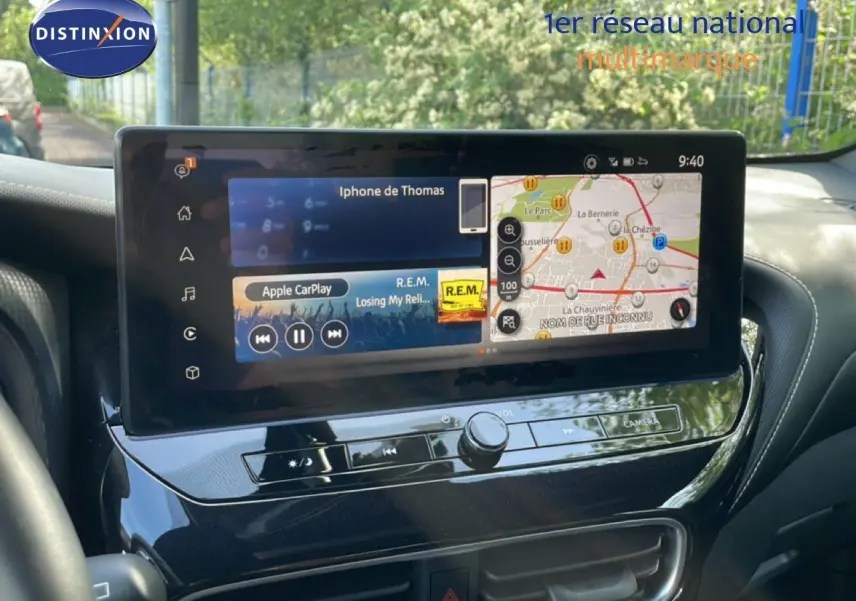 Écran tactile central du Nissan Juke 2025 noir, affichant navigation GPS et interface Apple CarPlay, vue intérieure avant.