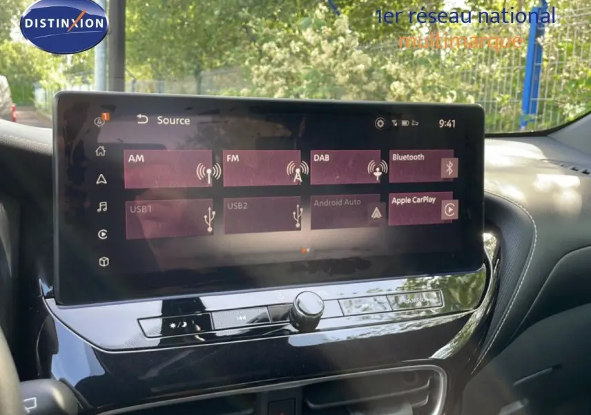 Écran tactile central du Nissan Juke 2025 affichant les options multimédias avec tableau de bord noir brillant.