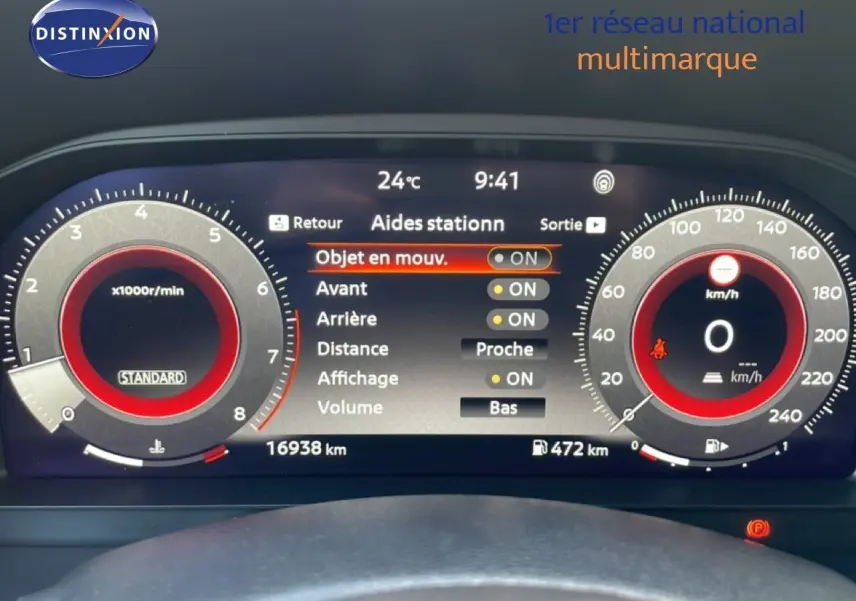 Tableau de bord numérique du Nissan Juke 2025 noir, affichant les aides au stationnement et compteurs à aiguille digitales.