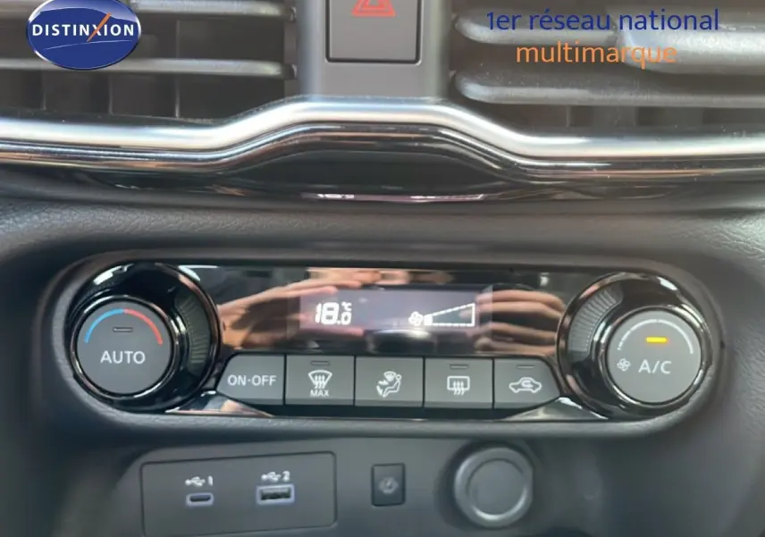 Détail de la console de climatisation automatique du Nissan Juke noir Kuro Metal, avec affichage digital et commandes rotatives.