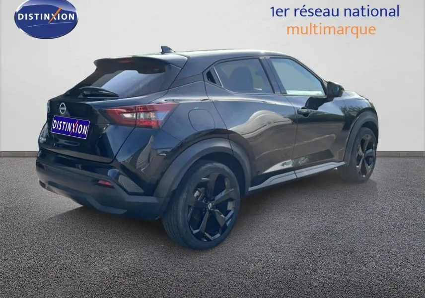 Nissan Juke 2025 noir Kuro Metal en 3/4 arrière droit, avec jantes noires et lignes sculptées visibles.