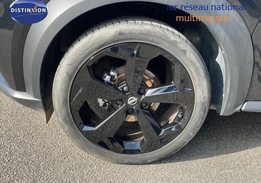 Gros plan sur la roue avant droite noire brillante du Nissan Juke 2025 noir Kuro Metal avec jante design.
