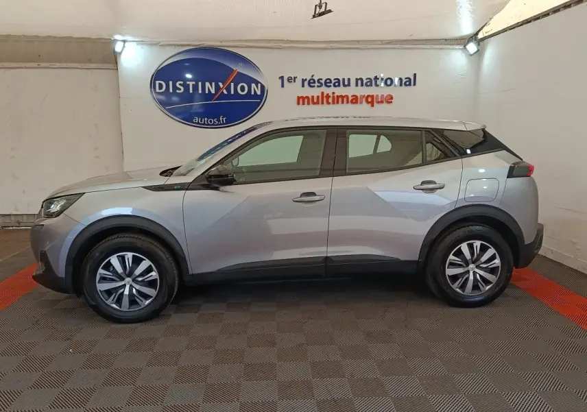 Profil côté gauche du Peugeot E-2008 électrique gris clair 2023, avec jantes alliage et toit noir contrastant.
