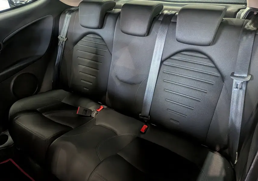 Banquette arrière en tissu noir de l'Alfa Romeo MiTo 2018, vue intérieure montrant les ceintures de sécurité et appuie-têtes.