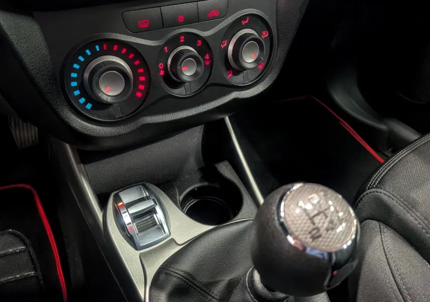 Gros plan sur la console centrale de l'Alfa Romeo MiTo 2018, montrant la commande de climatisation et le levier de vitesse manuel.