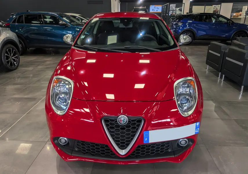 Vue frontale d'une Alfa Romeo MiTo rouge Alfa de 2018, avec calandre triangulaire caractéristique et phares ronds LED.
