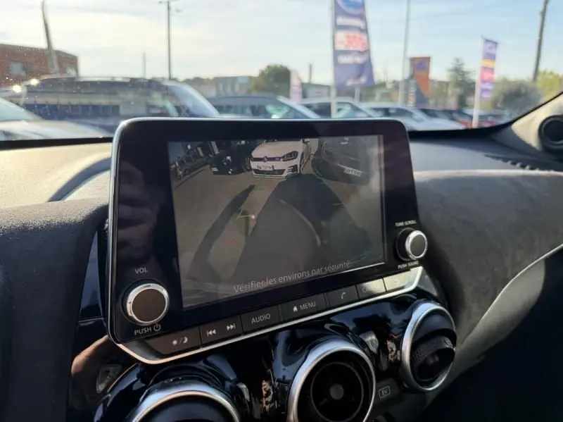Écran central du Nissan Juke 2024 montrant la caméra de recul, avec tableau de bord noir et aérateurs ronds.