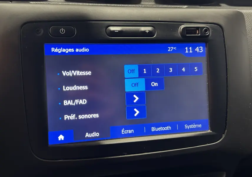 Écran tactile central du Dacia Duster 2018 affichant les réglages audio avec interface bleue et boutons de volume.