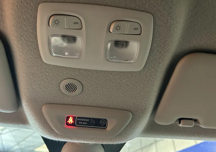 Plafonnier intérieur avec éclairages et témoin de ceinture allumée sur Dacia Duster noir, vue vers le toit depuis l'avant.