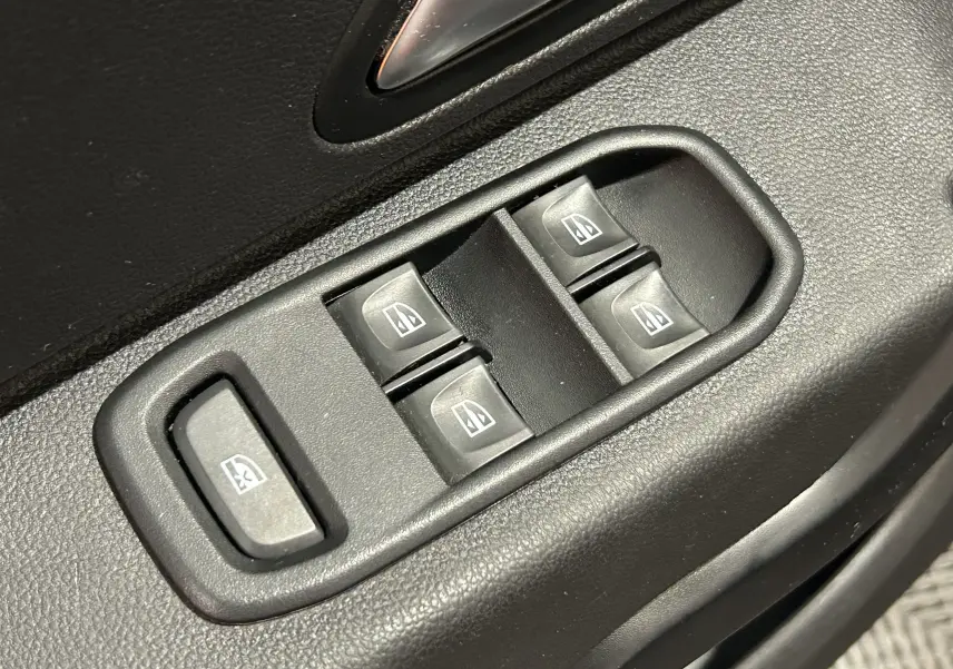Gros plan sur les commandes des vitres électriques côté conducteur du Dacia Duster noir, version Prestige 2018.