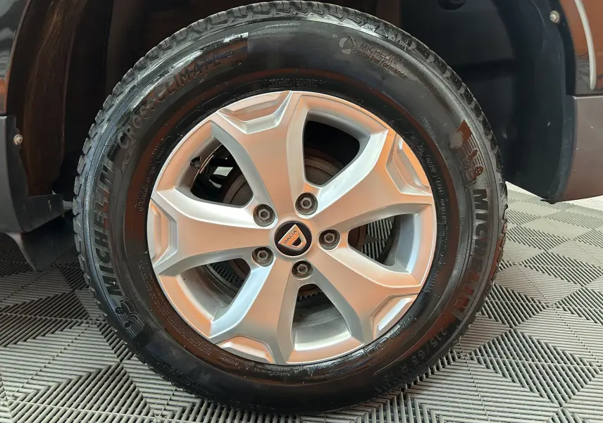 Gros plan sur la roue avant gauche du Dacia Duster noir, mettant en valeur la jante alliage et le pneu Michelin.