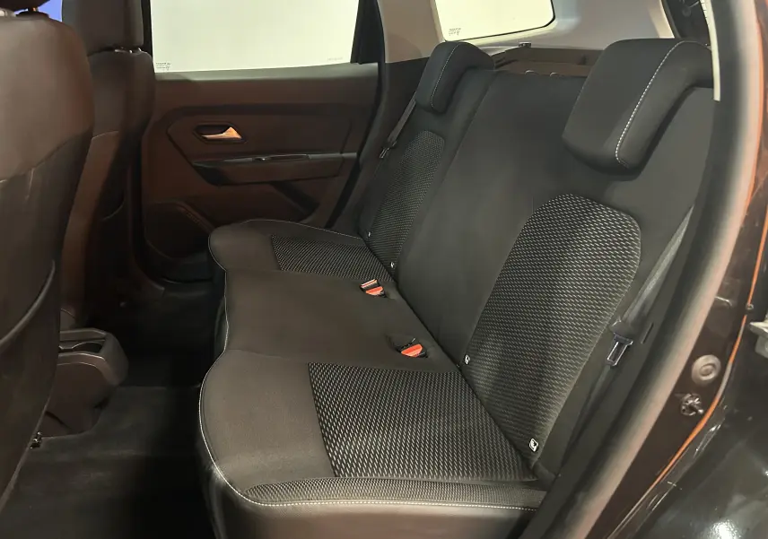 Vue intérieure côté droit des sièges arrière noirs en tissu du Dacia Duster 2018, avec appuie-têtes et ceinture de sécurité visibles.