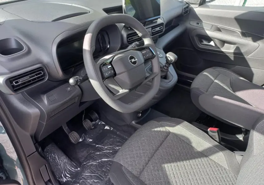 Vue intérieure côté conducteur de l’Opel Combo Life M 2025, avec volant, tableau de bord et sièges en tissu gris.