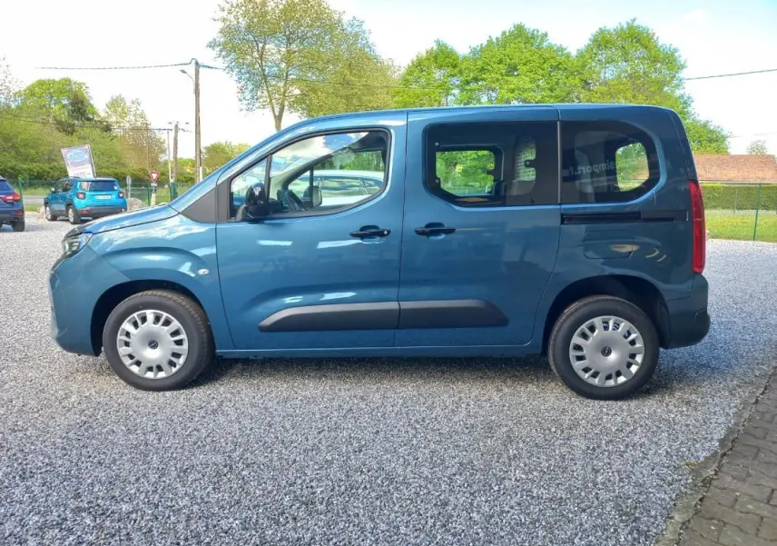 Vue de profil côté gauche d’un Opel Combo Life bleu 2025 avec portes coulissantes et jantes acier.