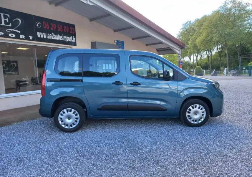 Vue de profil côté droit d'un Opel Combo Life bleu 2025 avec portes coulissantes et jantes acier argentées.