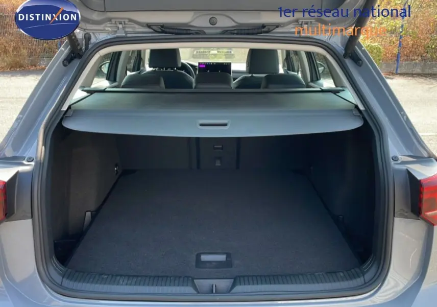 Coffre ouvert d’une Volkswagen Golf SW VIII gris lunaire métal, vue arrière montrant l’espace de chargement et l’intérieur des sièges.