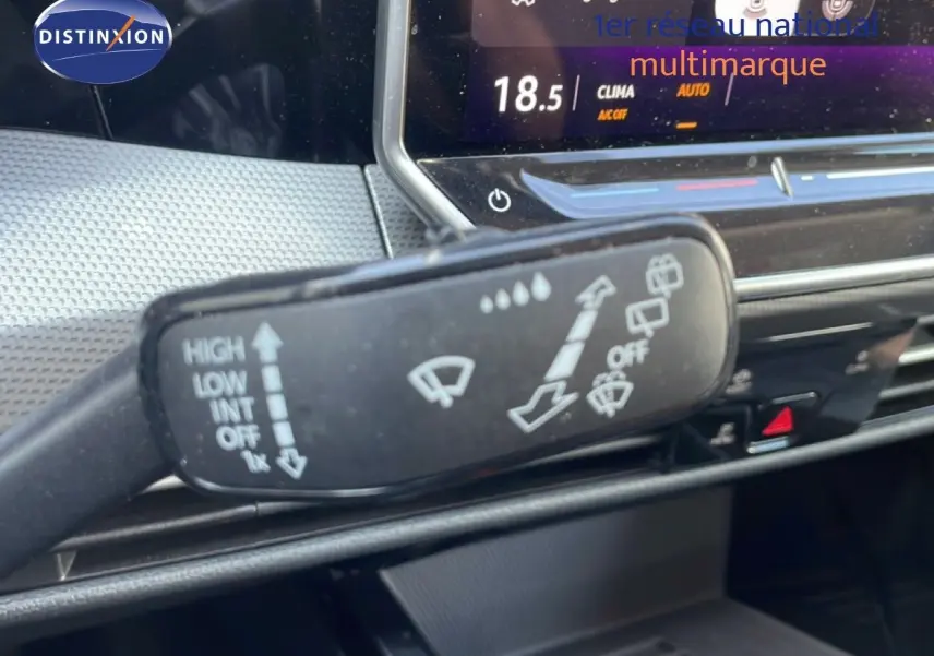 Gros plan sur la commande d’essuie-glace dans l’habitacle gris noir de la Volkswagen Golf SW VIII 2024.