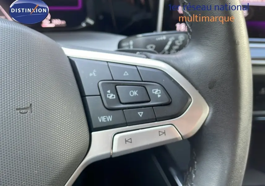 Gros plan sur les commandes au volant en cuir noir de la Volkswagen Golf SW VIII 2024, détails des boutons multifonctions.