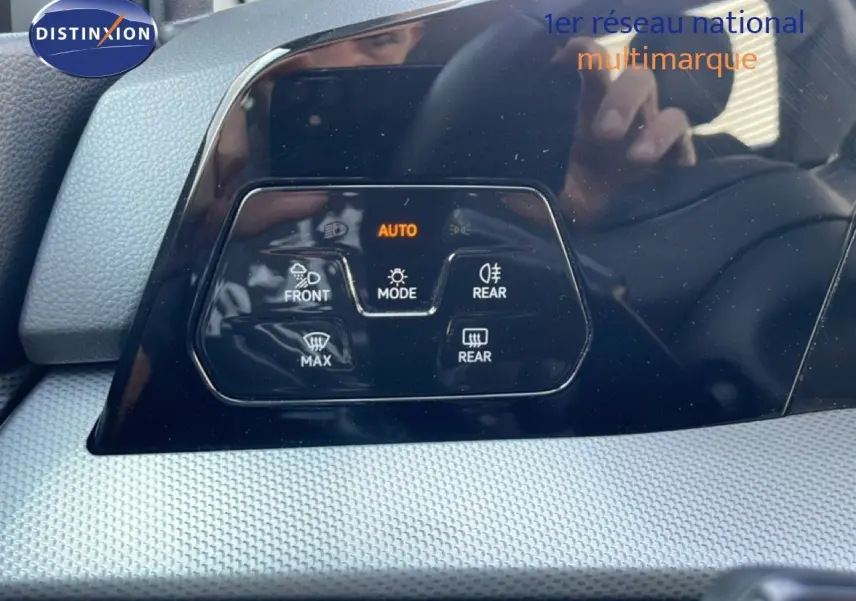 Gros plan sur le tableau de bord noir brillant de la Volkswagen Golf SW VIII gris lunaire, affichant les commandes de climatisation.
