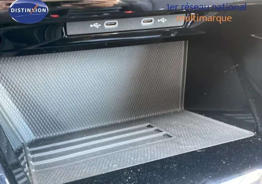 Gros plan sur la console centrale de la Volkswagen Golf SW VIII 2024, montrant les ports USB et un espace de rangement texturé.