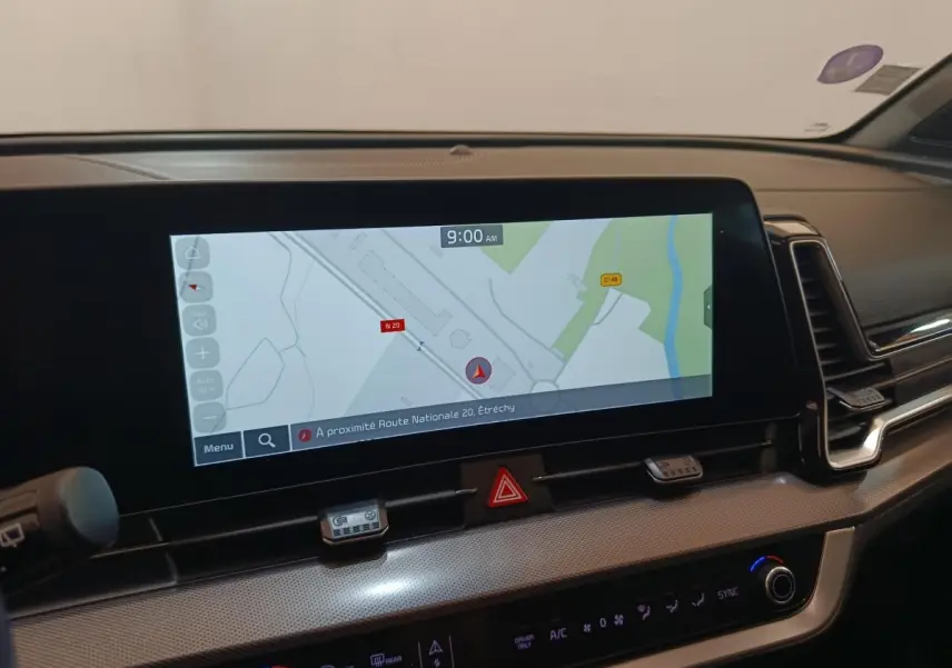 Intérieur du Kia Sportage 2022, vue sur l'écran tactile central affichant la navigation, tableau de bord moderne noir.