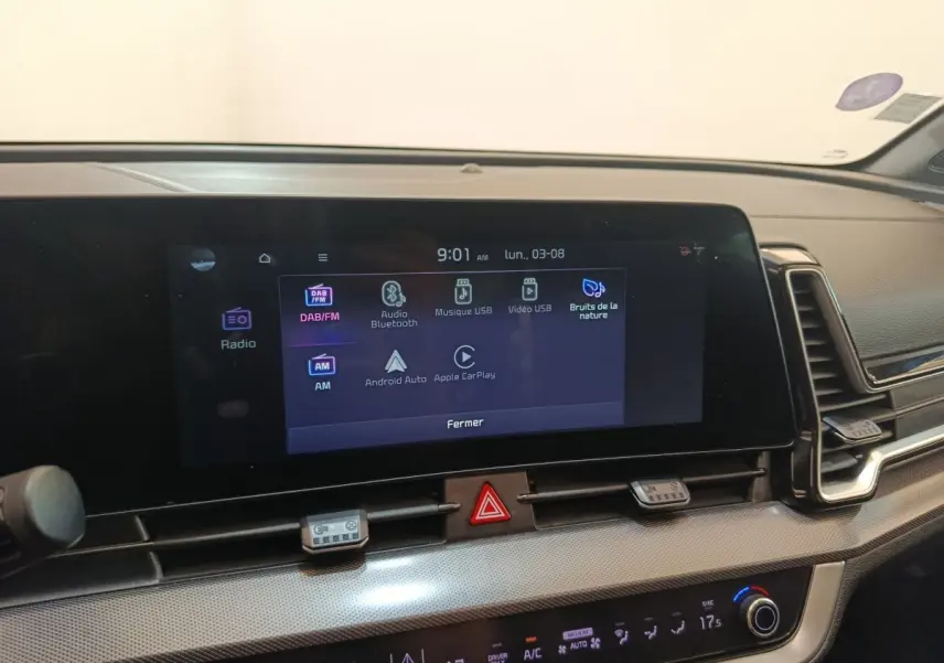 Vue intérieure du tableau de bord du Kia Sportage gris clair 2022, écran tactile multimédia allumé.