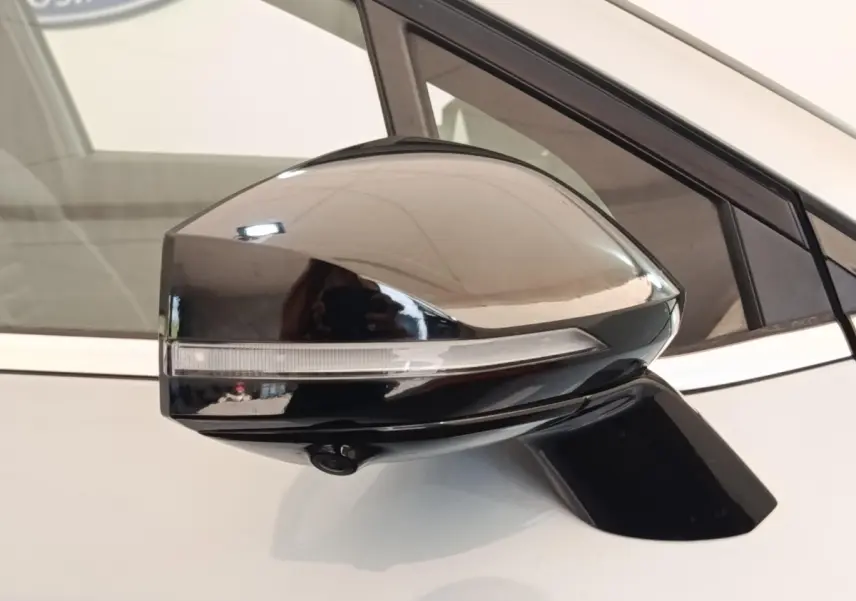Gros plan sur le rétroviseur droit noir brillant avec clignotant intégré du KIA Sportage gris clair 2022.