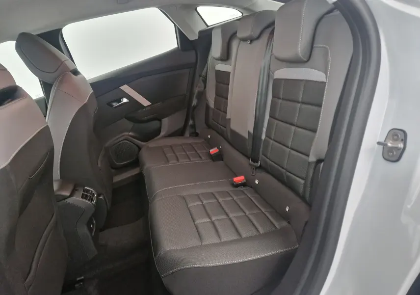 Vue intérieure côté droit des sièges arrière en tissu noir et gris du Citroën C4 blanc Okenite 2025.