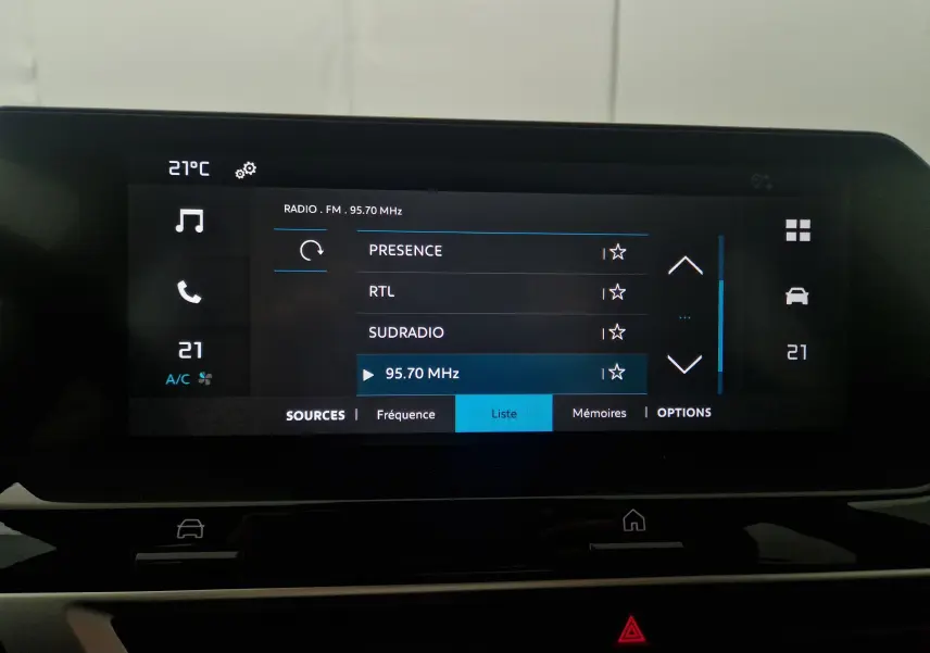 Écran tactile central de la Citroën C4 2025 affichant la liste des radios FM avec température intérieure à 21°C.